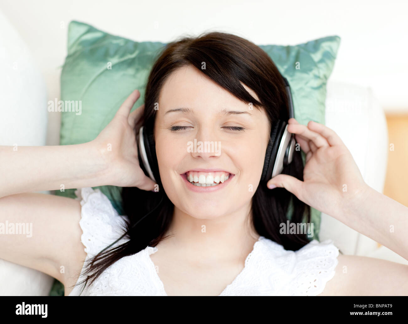 Jolly teen girl listening music lying on a sofa Stock Photo - Alamy