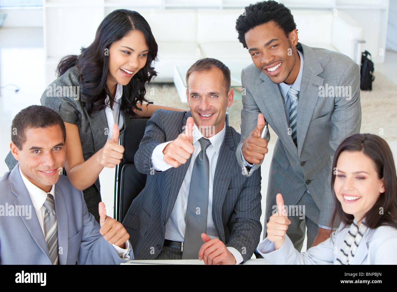 Happy Business team with thumbs up in office Stock Photo - Alamy