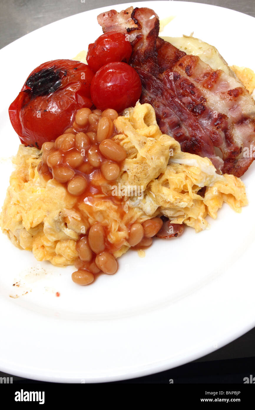 Individual portion of scrambled eggs baked beans bacon tomatoes Stock Photo