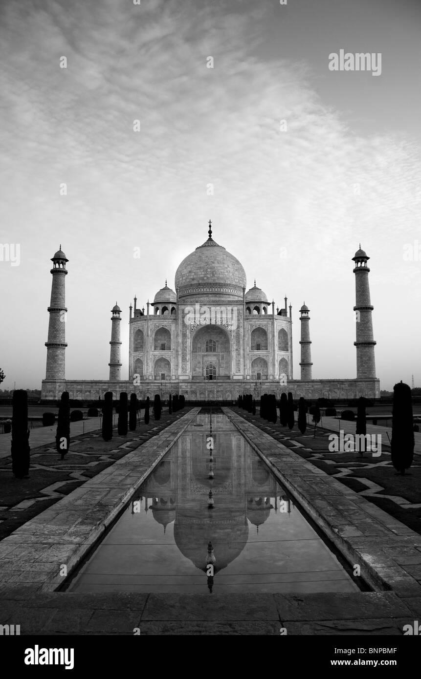 The magnificent Taj Mahal is reflected in the reflecting pool during sunrise. Stock Photo