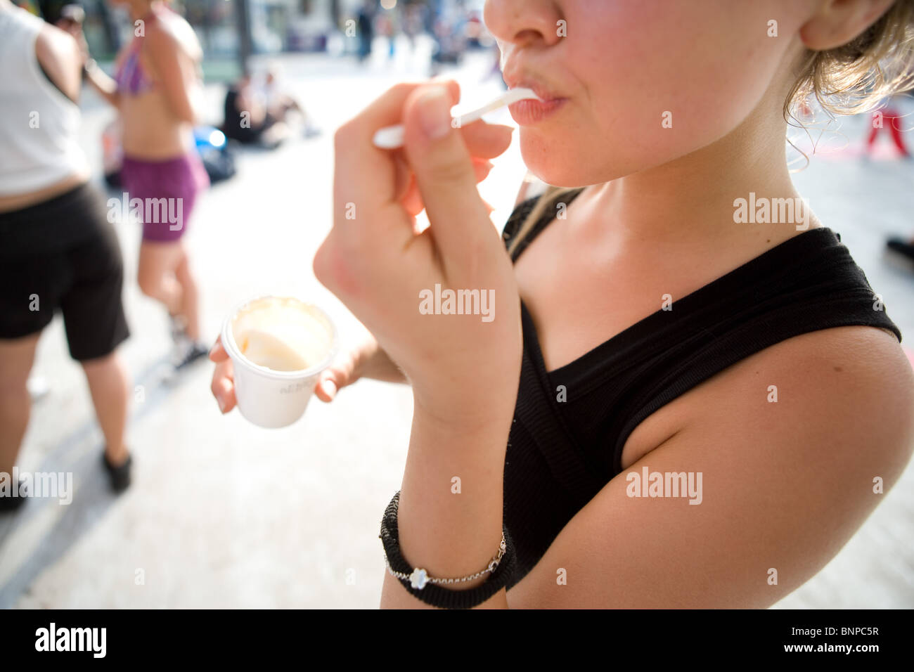 young girl eat yogurt outdoor spot detail close up Stock Photo