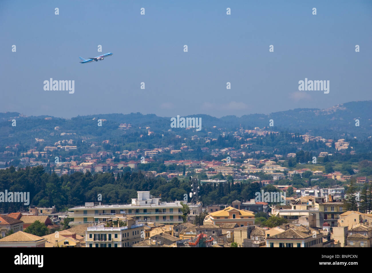 Thomson tourist aircraft taking off over Corfu Town on the Greek island of Corfu Greece GR Stock Photo