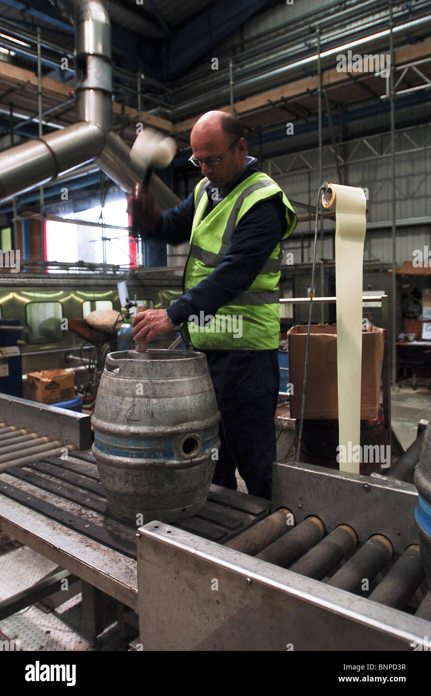 A man hammers in a plug to a keg at the Charles Wells brewery Bedford UK Stock Photo