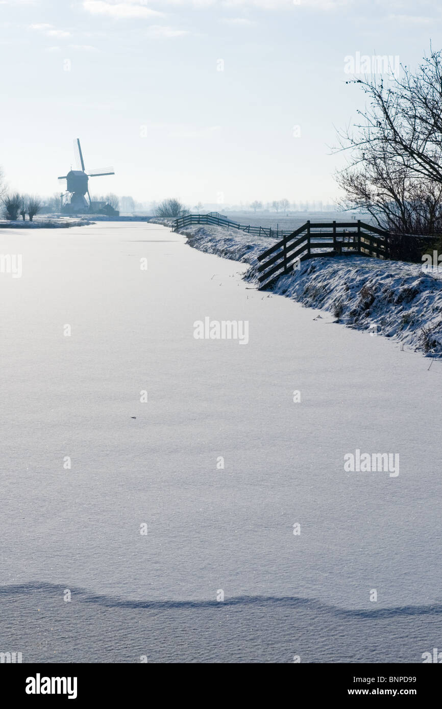 Frozen river and windmill in Holland during winter Stock Photo