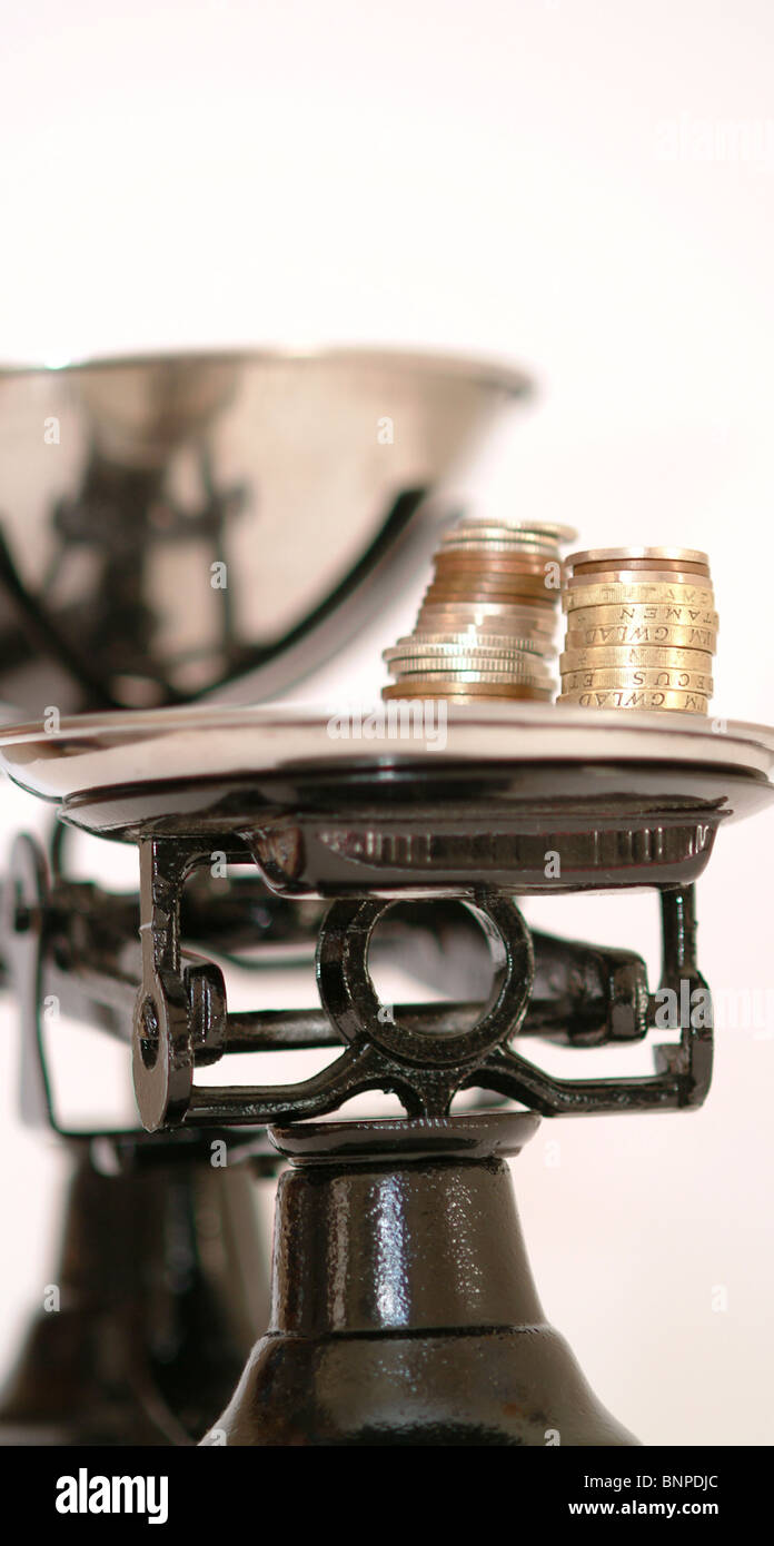 A set of black scales with coins as the weights UK Stock Photo