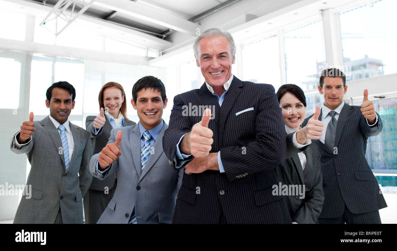 Happy business team with thumbs up Stock Photo - Alamy