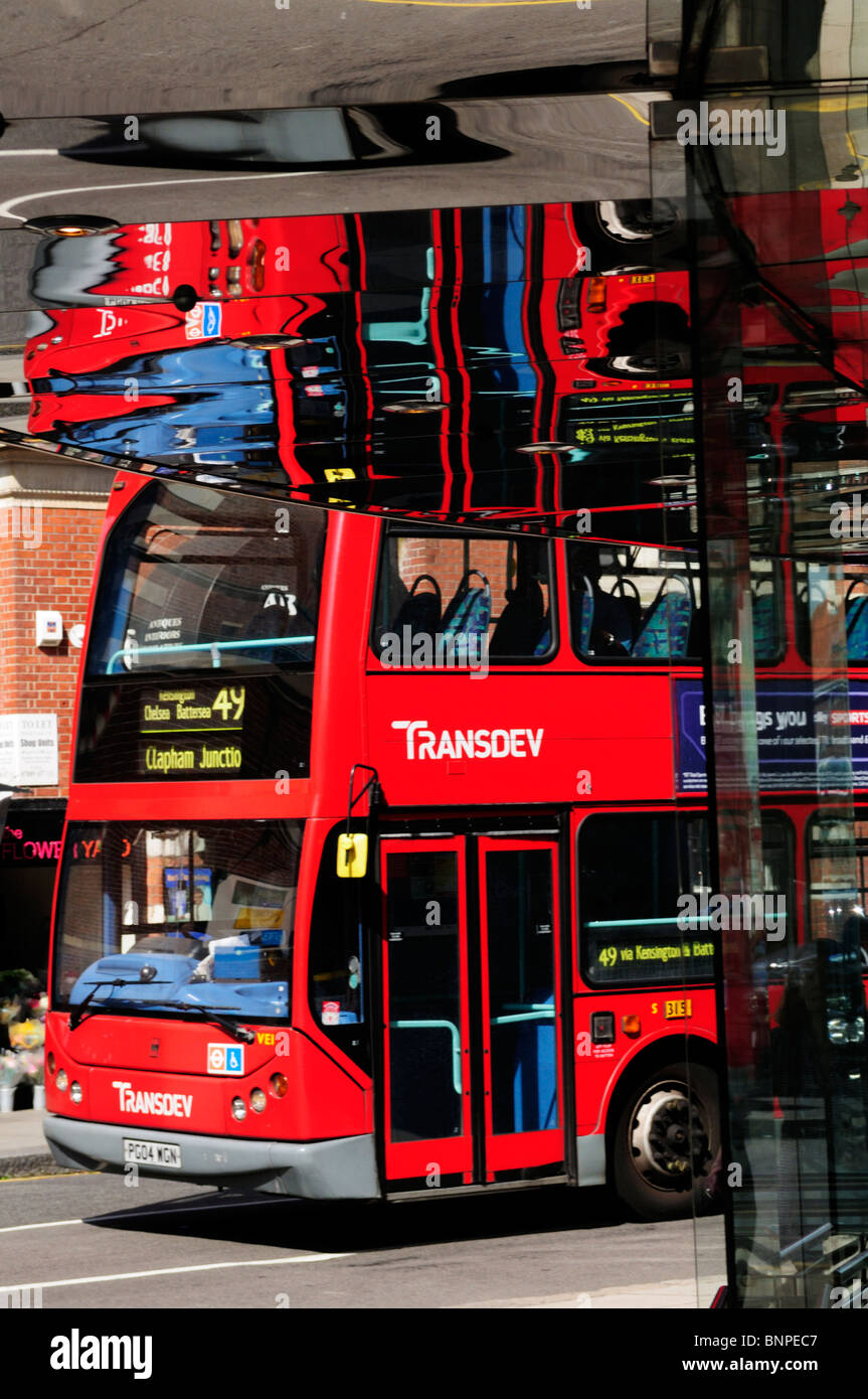 Red London bus with reflections in shop, King's Road, Chelsea, London, England, UK Stock Photo