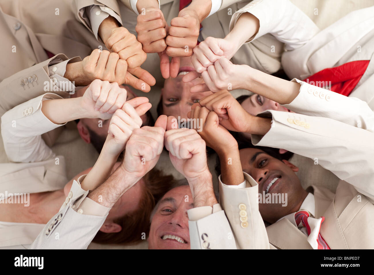 Smiling business people with thumbs up lying on the floor Stock Photo ...