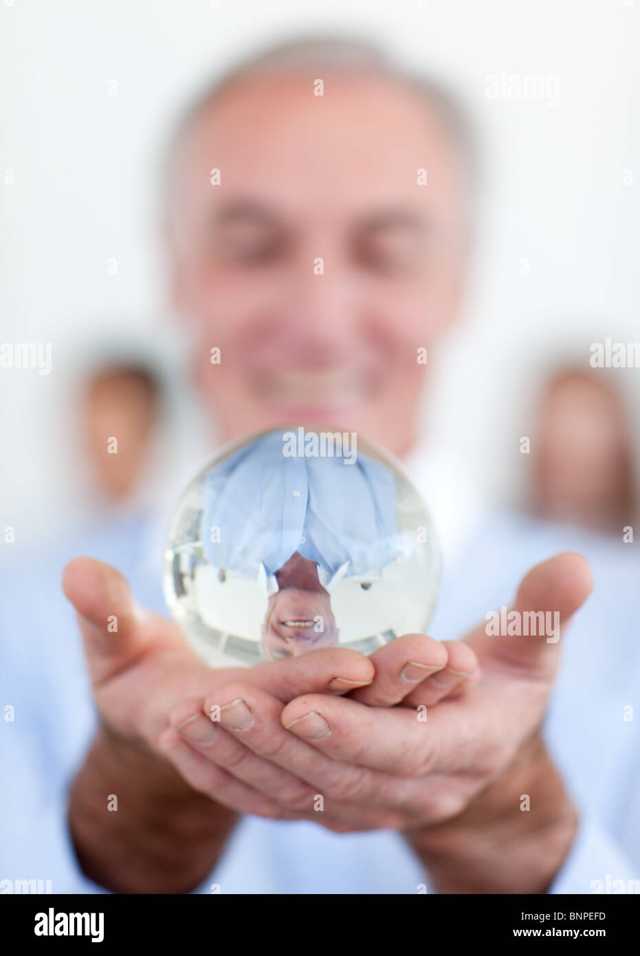 Senior businessman holding a crystal ball Stock Photo - Alamy
