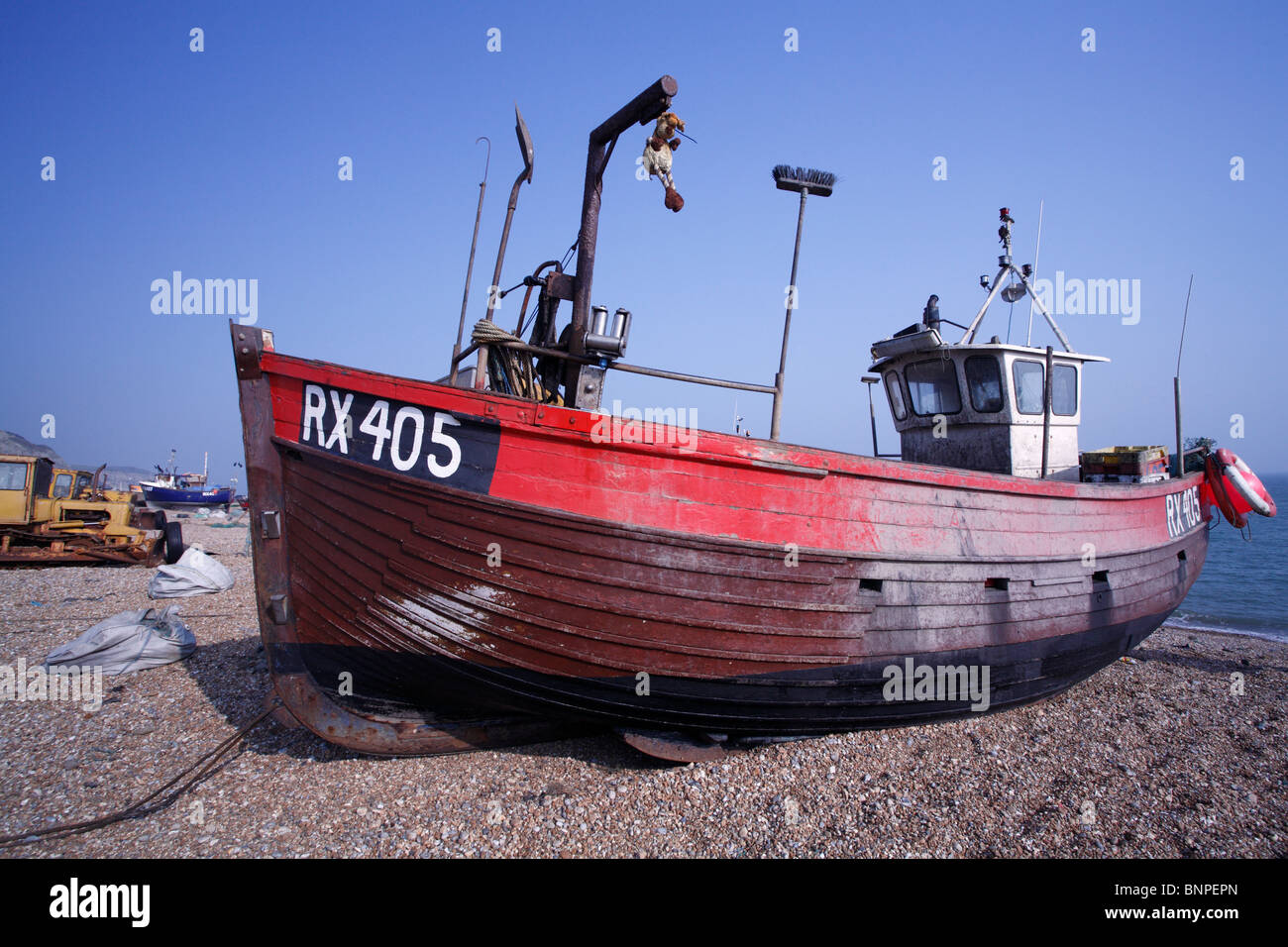 An old red fishing boat on the shingle beach at Hastings. A very old ...