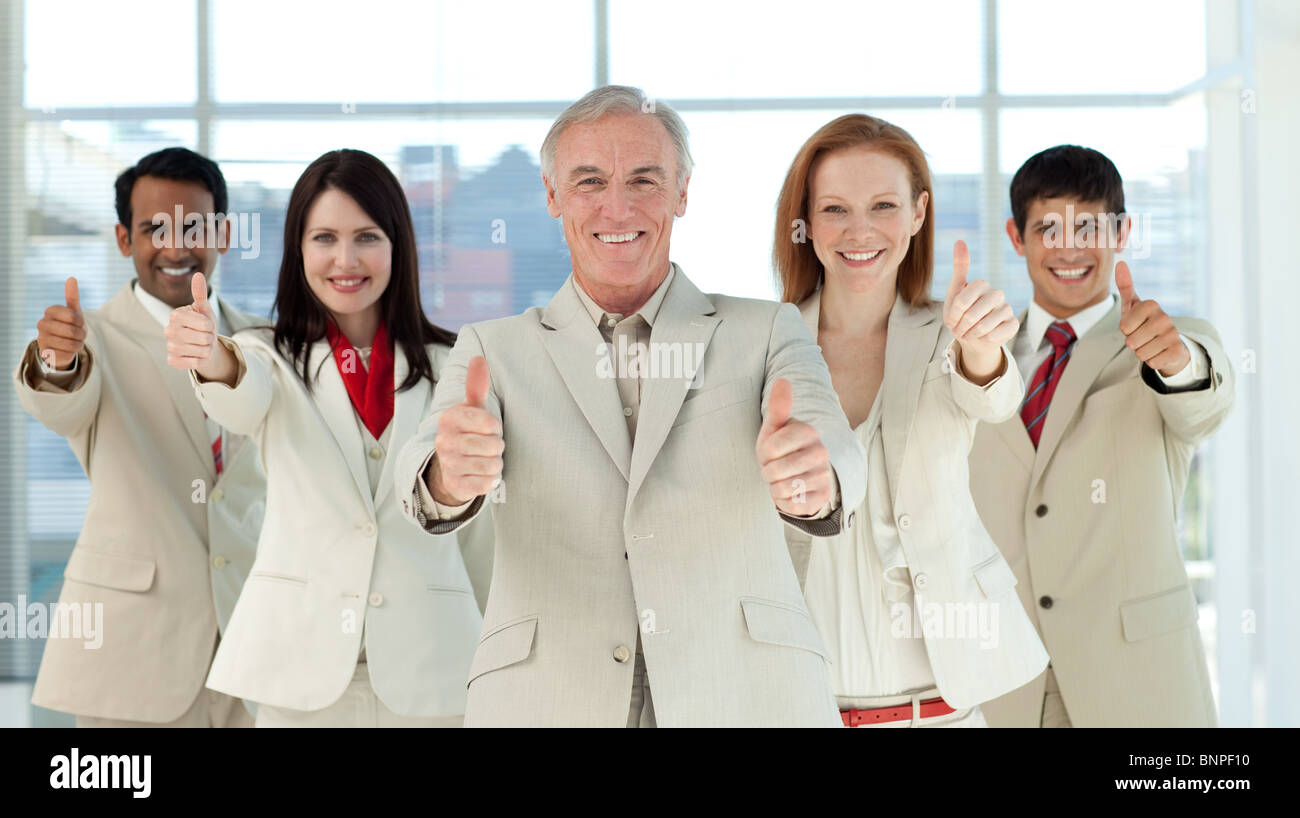 Smiling business team with thumbs up Stock Photo - Alamy