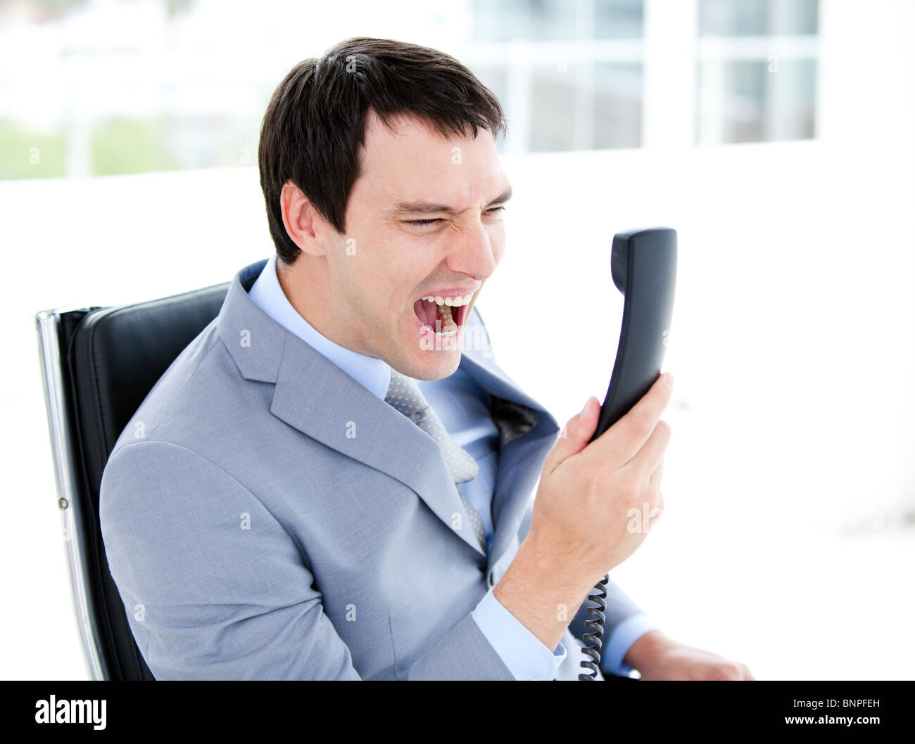 Furious young businessman yelling on phone Stock Photo
