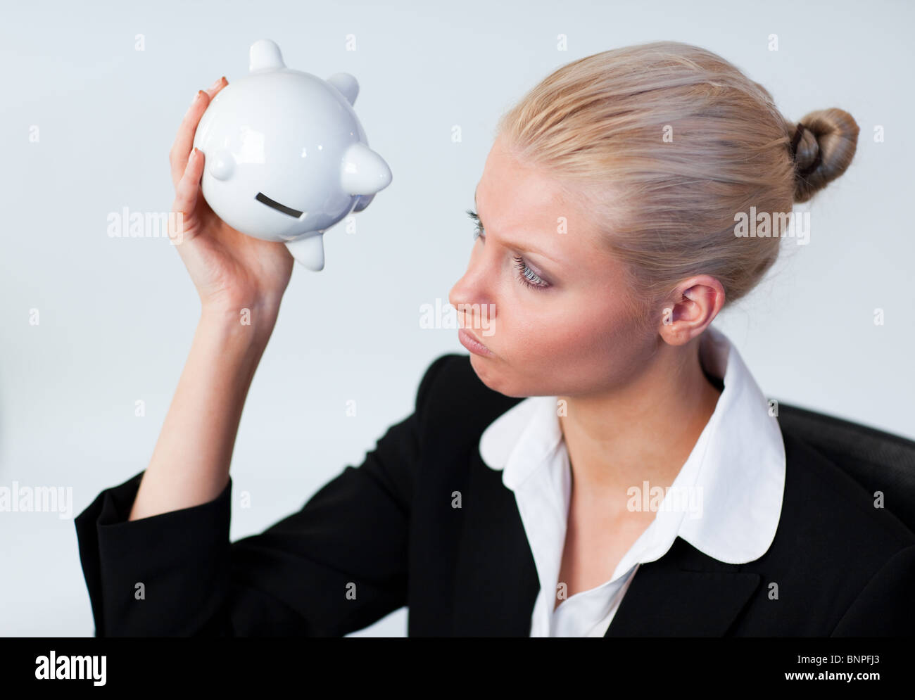 Sad Business woman looking into Piggy Bank Stock Photo - Alamy