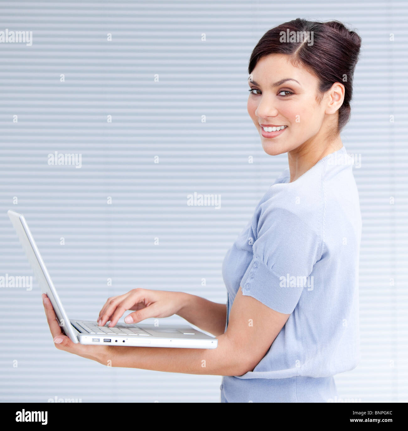 Cheerful businesswoman using a laptop Stock Photo - Alamy