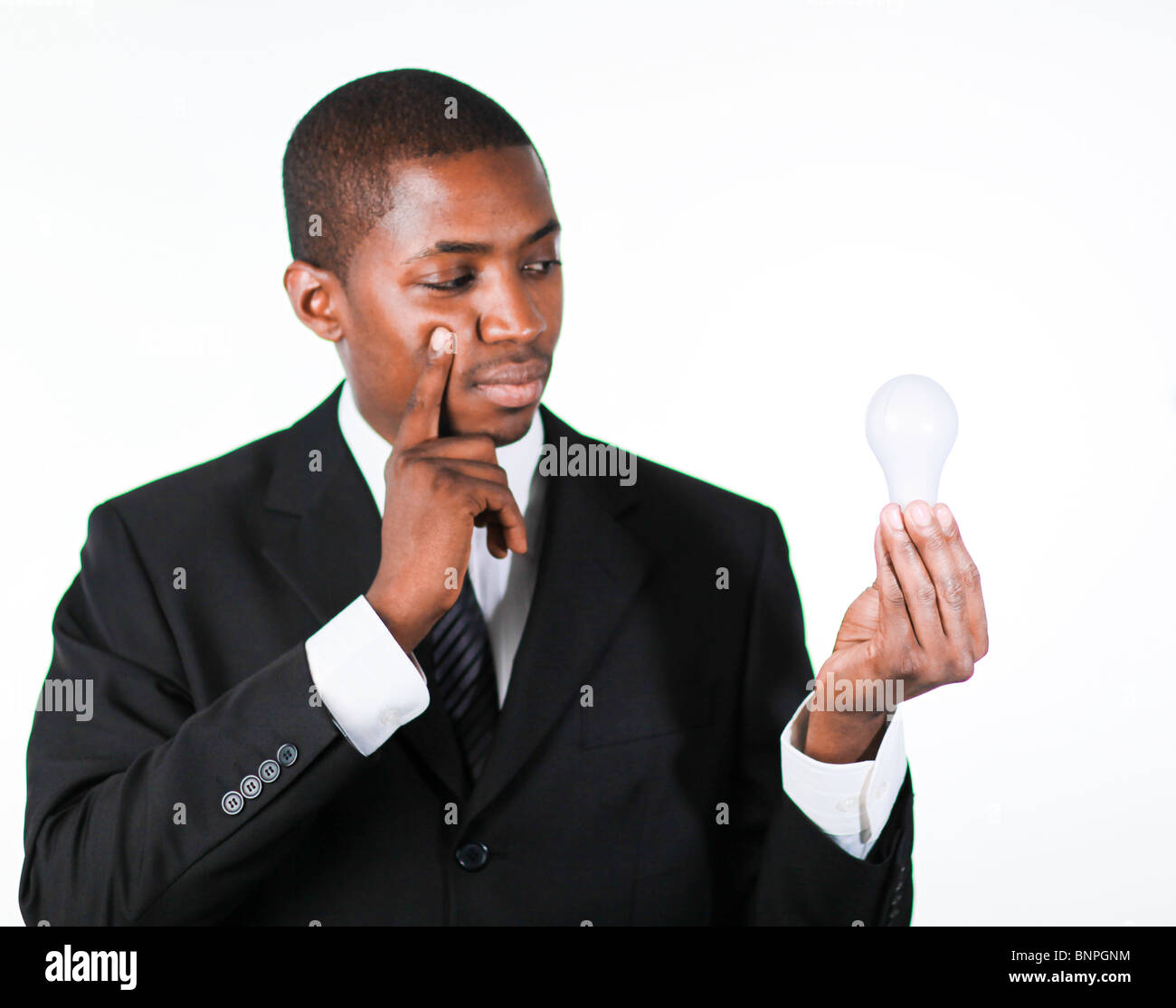 Thoughtful businessman holding a light bulb Stock Photo - Alamy