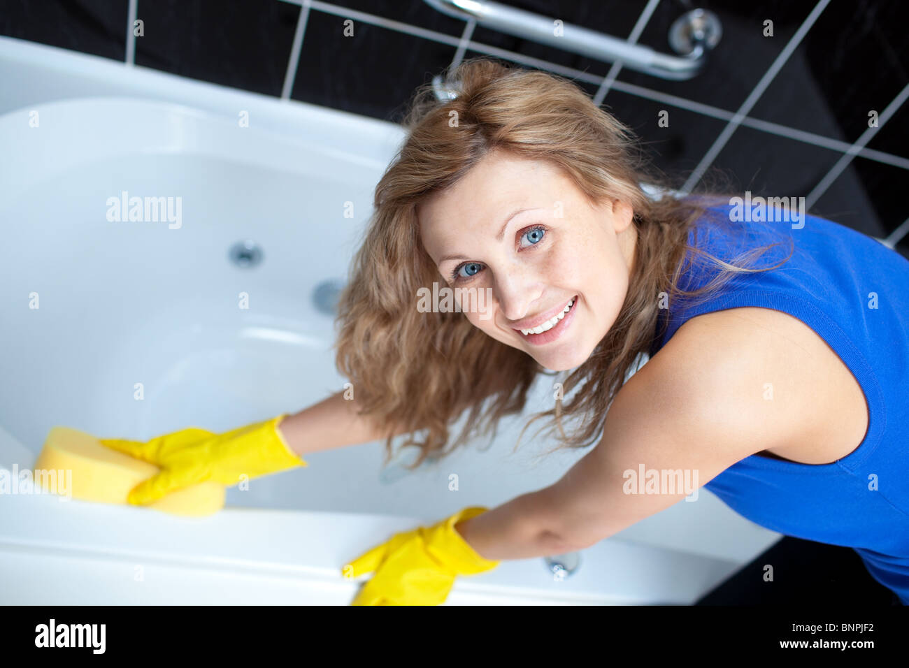 Smiling woman cleaning a bath Stock Photo Alamy