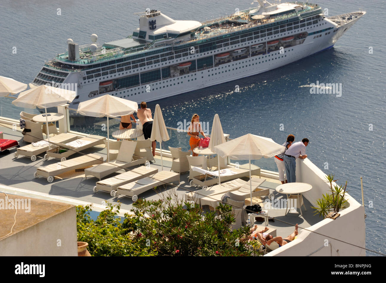 Hotel residents watching a cruise ship departing the caldera, Santorini Cyclades islands Greece Stock Photo