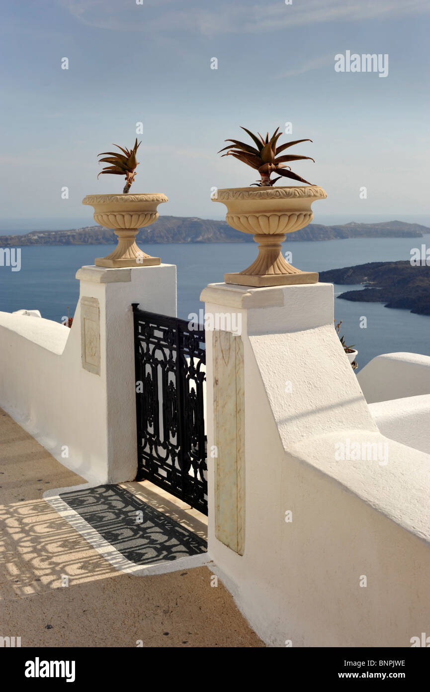 2 urns either side of a wrought iron gate leading to a villa at Firostfani Santorini in the Cyclades Greece Stock Photo