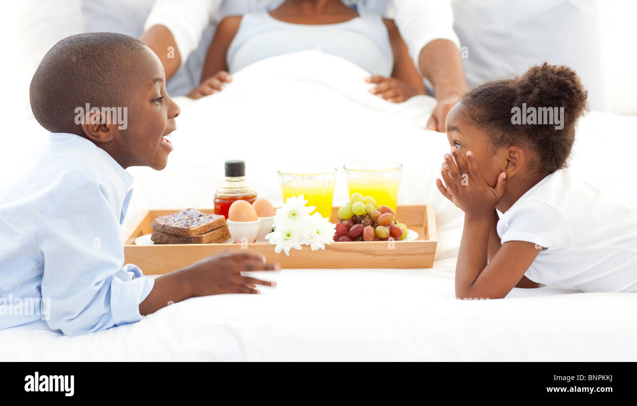 Happy family having breakfast in the bedroom Stock Photo - Alamy