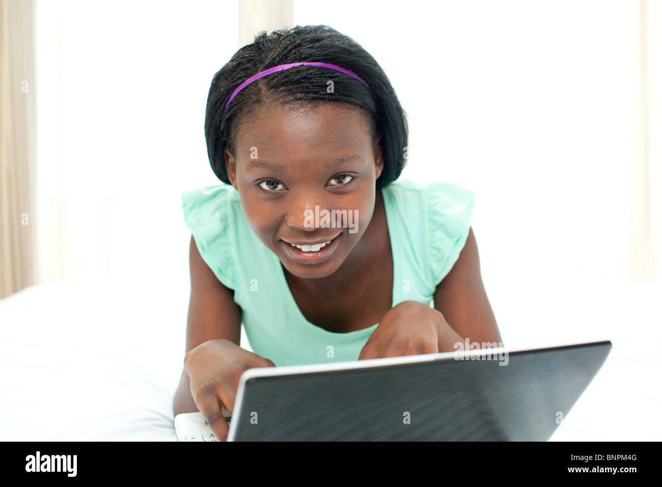 Charming woman using a laptop lying on her bed Stock Photo - Alamy
