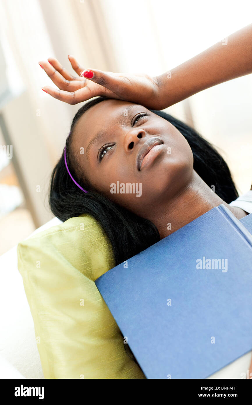 Tired woman reading lying on a sofa Stock Photo - Alamy