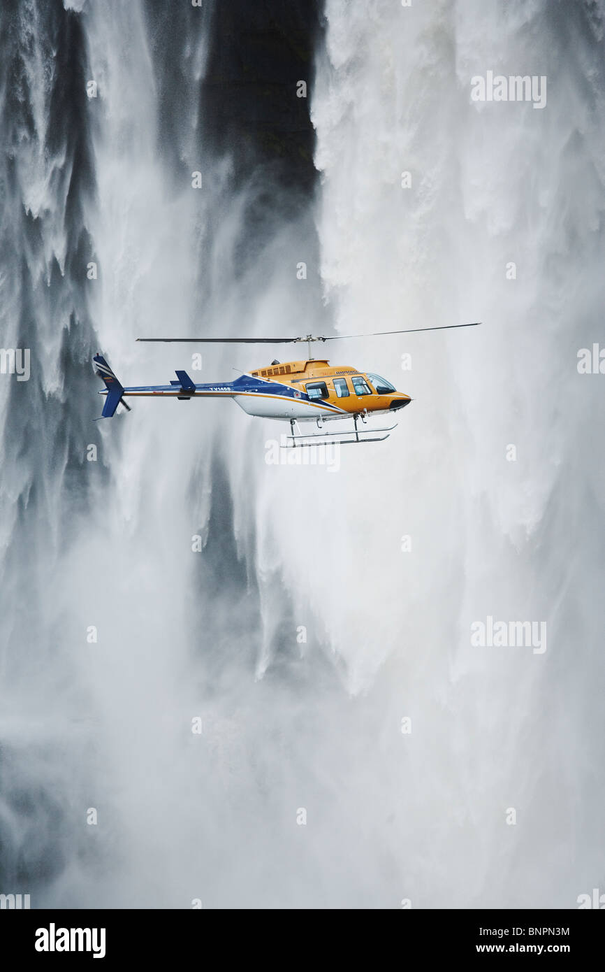 Helicopter flying in front of Aponwao waterfall Venezuela Stock Photo