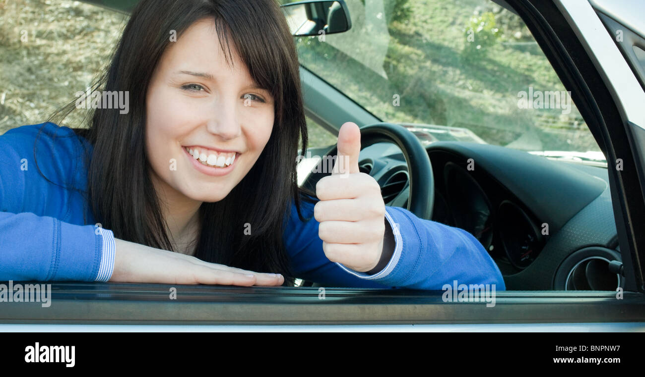 Happy teen girl with a thumb up sitting in her car Stock Photo - Alamy