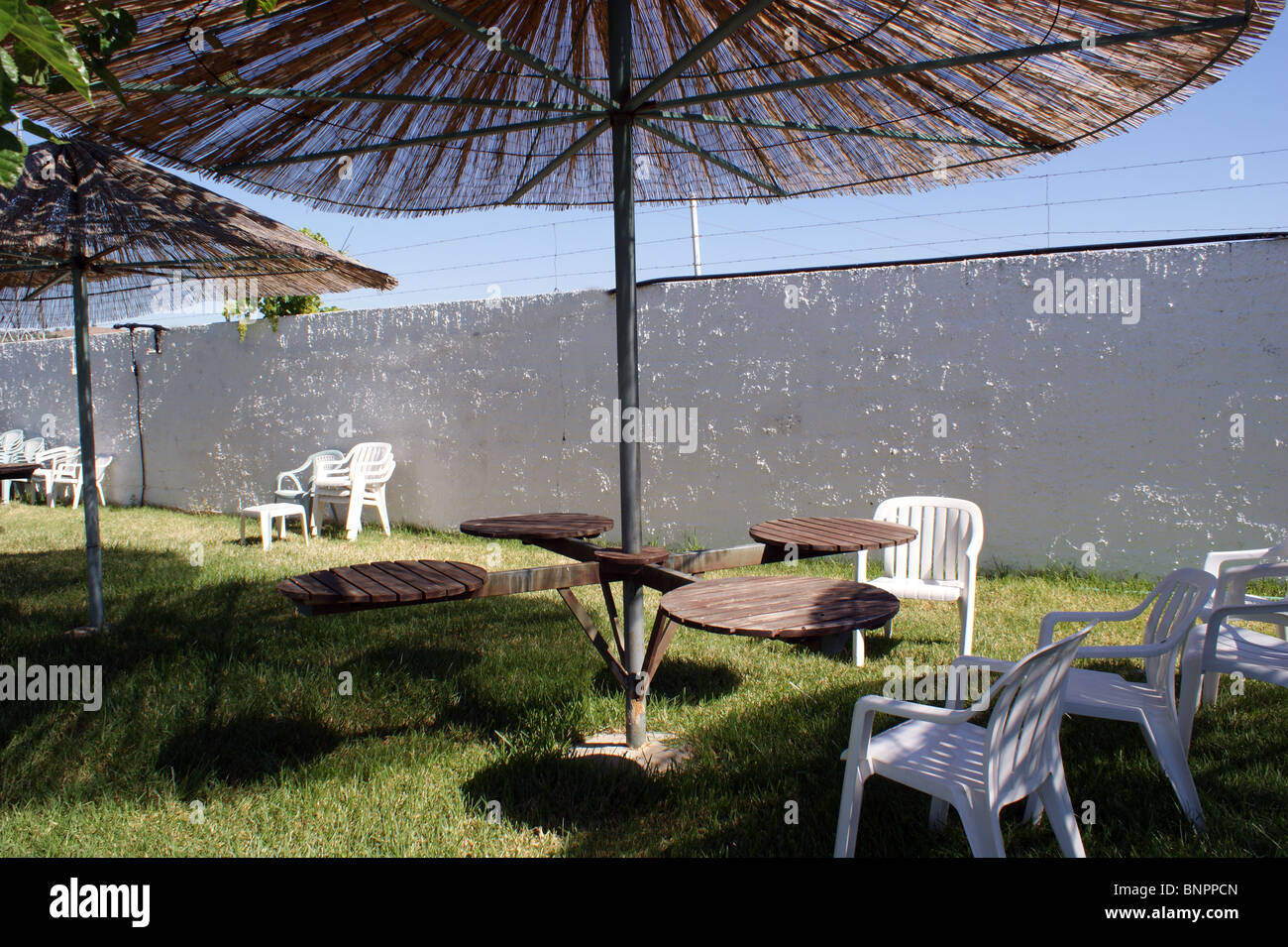 PICNIC TABLE AND PARASOL ON A GRASS PATIO IN  SPAIN ANDALUCIA Stock Photo