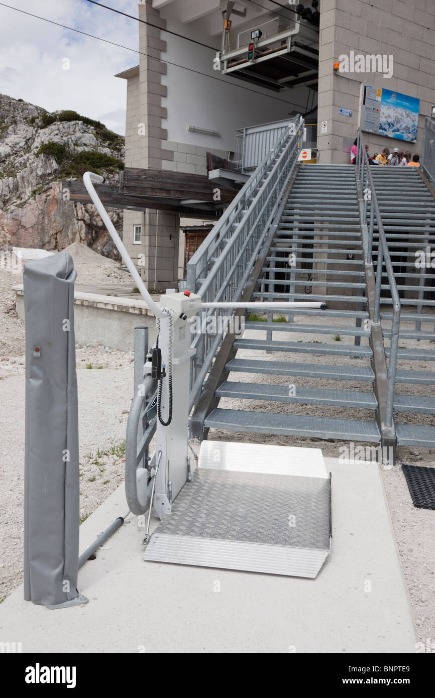 Wheelchair stair lift by steps outside Dachstein World Heritage cableway for disabled access on Krippenstein mountain. Ausrtia. Stock Photo