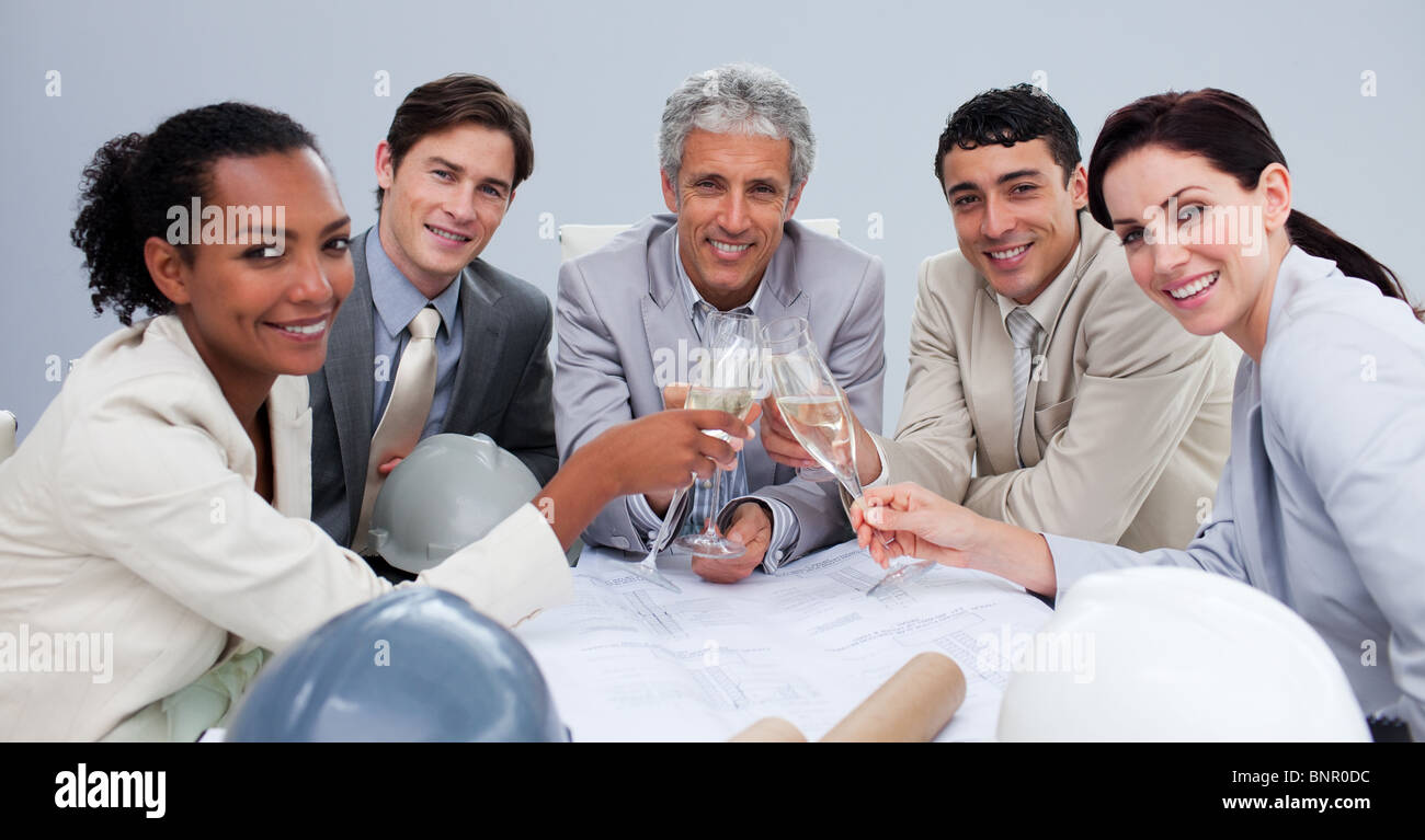 Smiling architectutal team celebrating a success with champagne Stock Photo