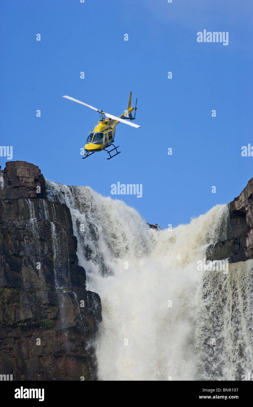 Helicopter flying in front of Aponwao waterfall Venezuela Stock Photo