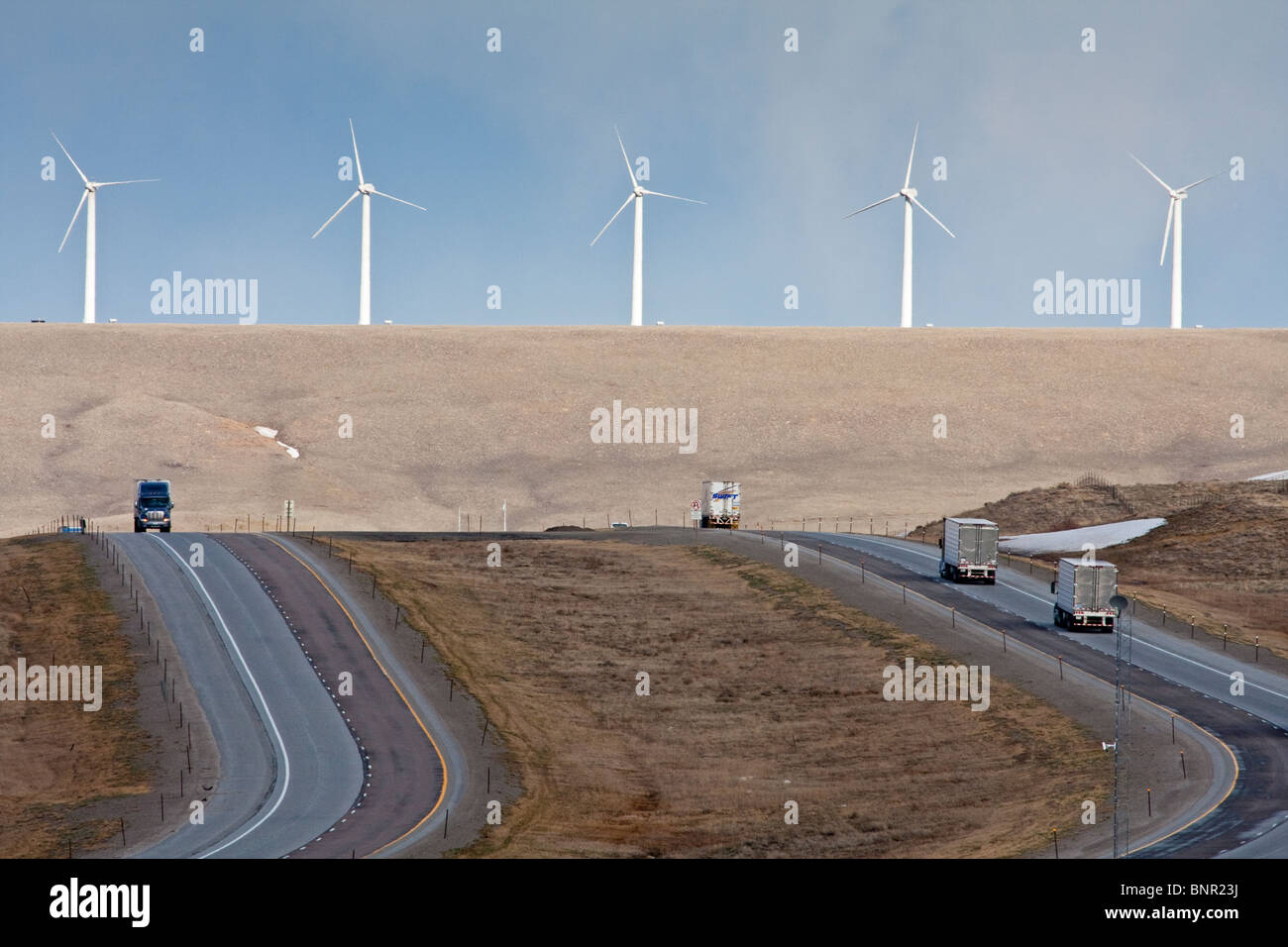 Wind generators tower above Interstate 80 in Wyoming. Stock Photo