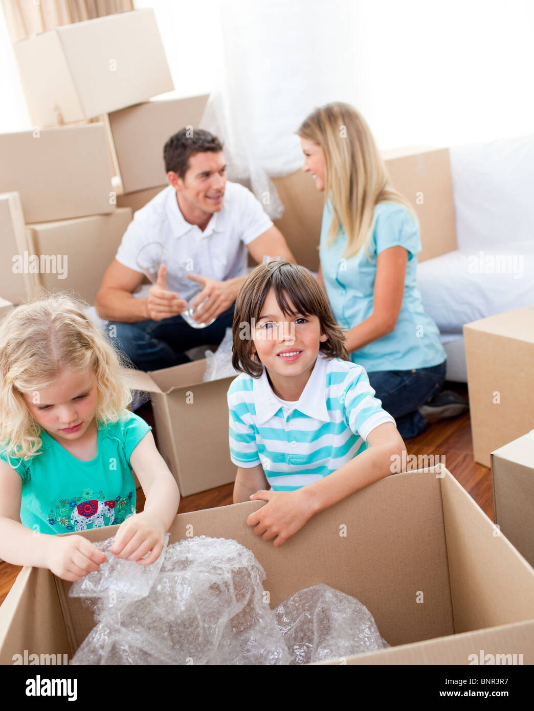 Cheerful family packing boxes Stock Photo - Alamy