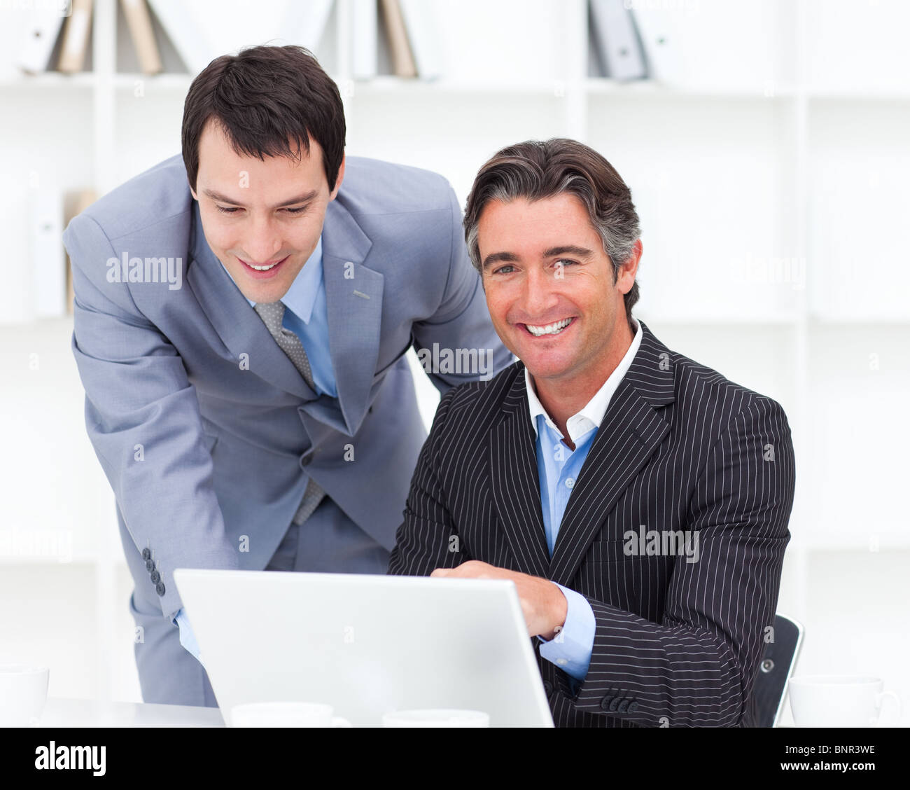 Portrait of two businessmen working at a computer Stock Photo - Alamy