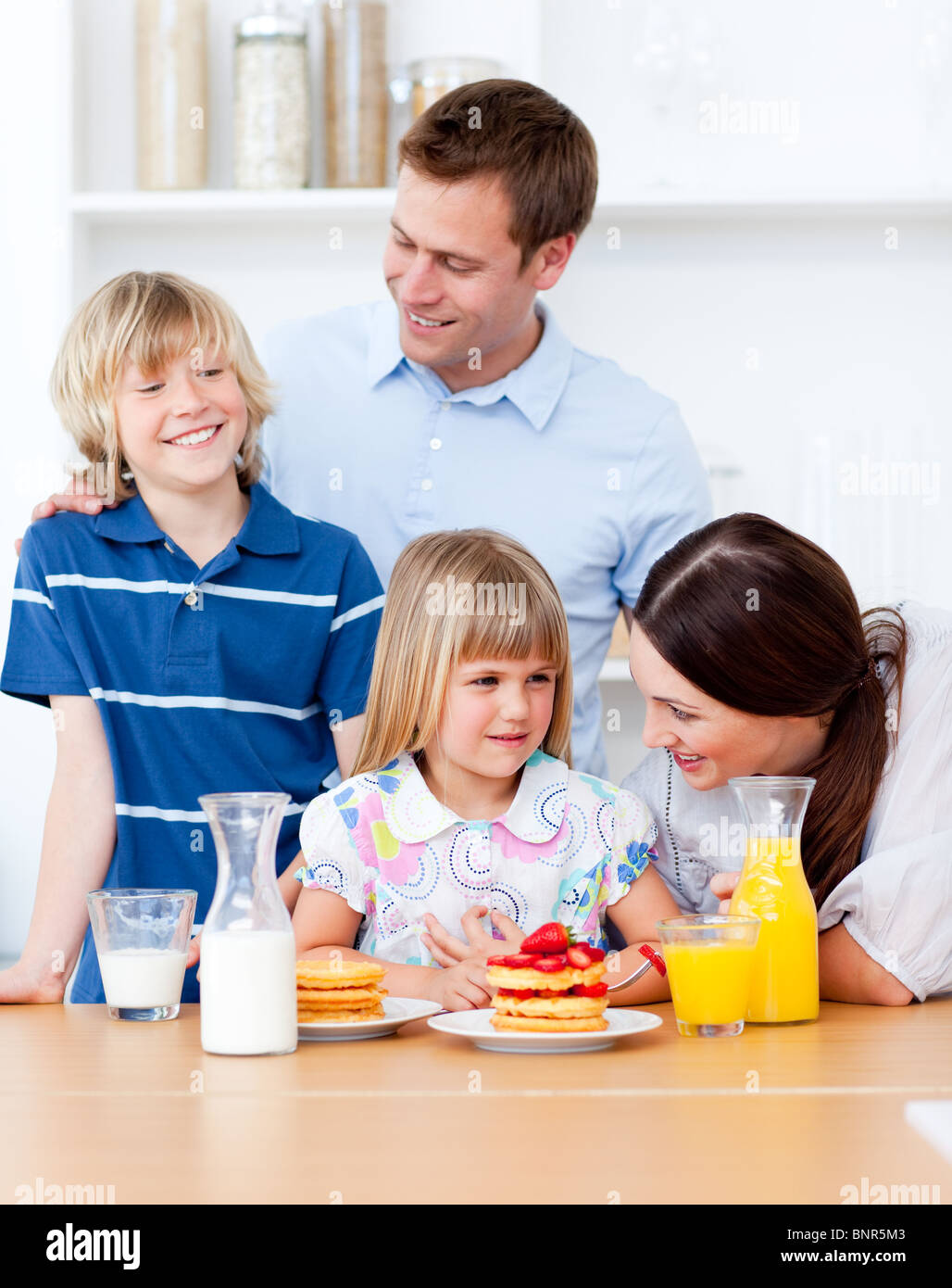 Jolly family eating breakfast in the kitchen Stock Photo