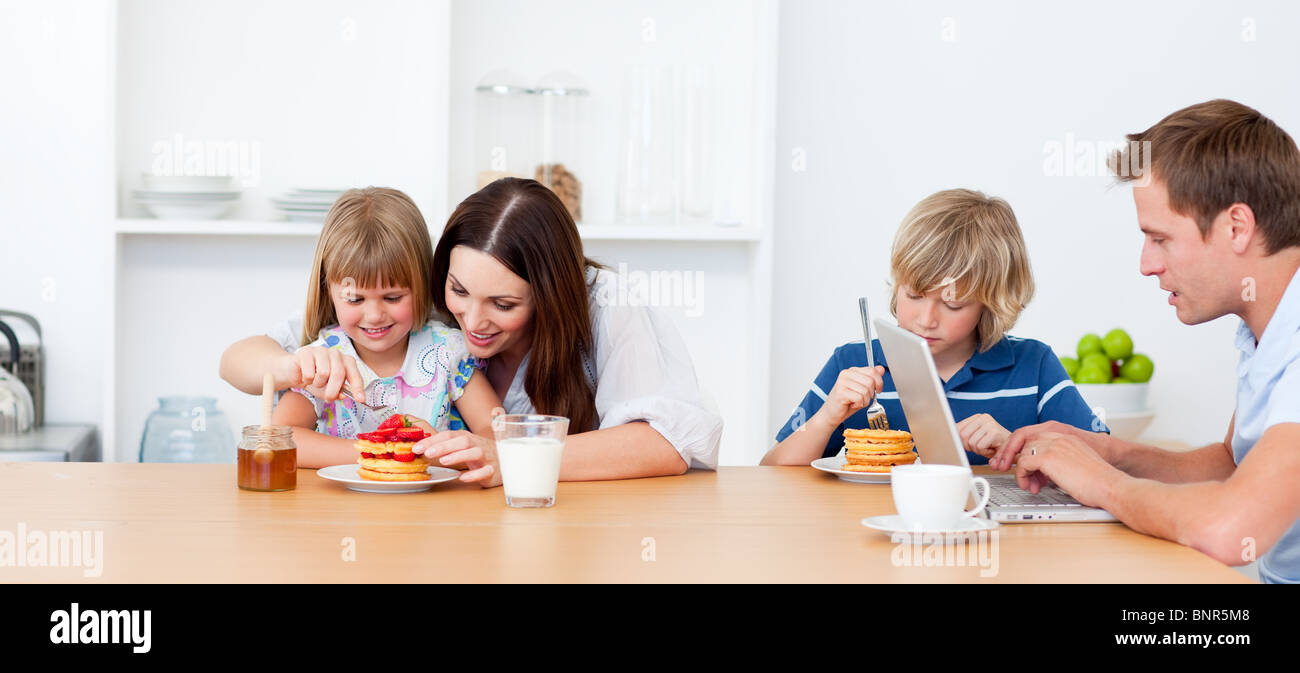 Merry family eating breakfast in the kitchen Stock Photo