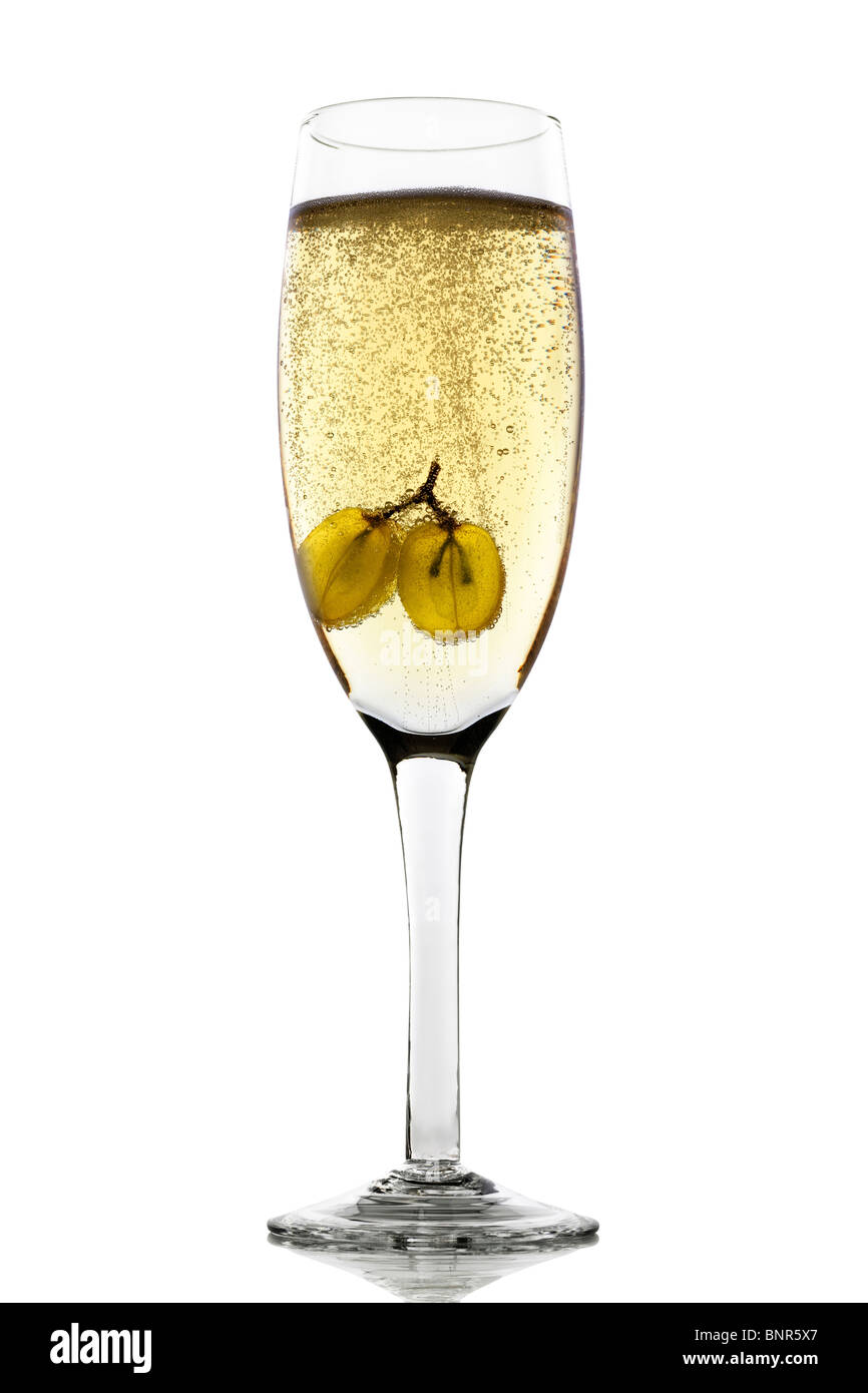 Grapes floating in champagne glass creating lots of bubbles Stock Photo