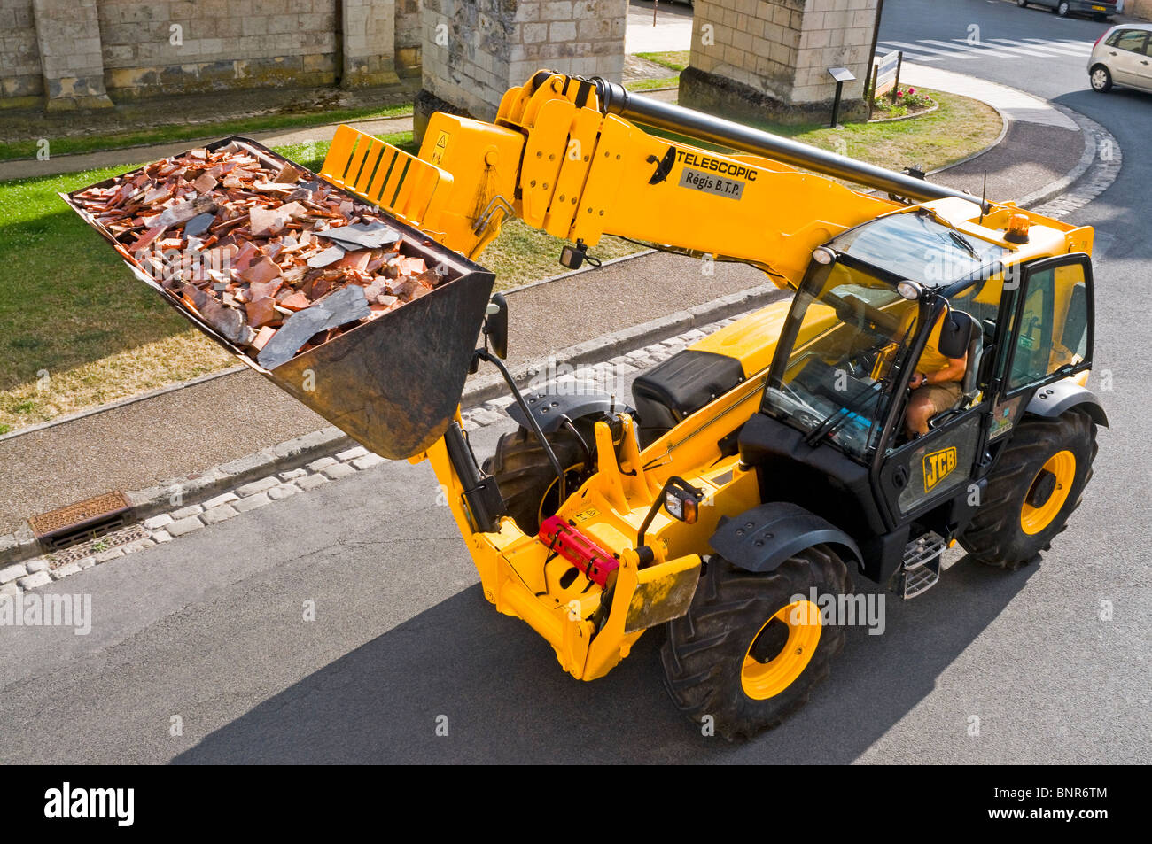 Yellow JCB Telescopic Handler carrying waste building materials - France. Stock Photo