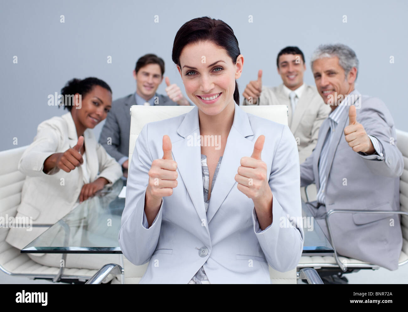 Happy business team with thumbs up Stock Photo - Alamy
