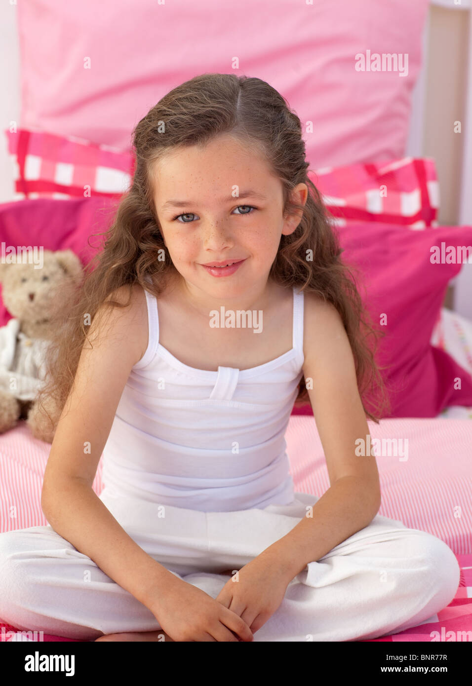 Little girl sitting on bed Stock Photo Alamy