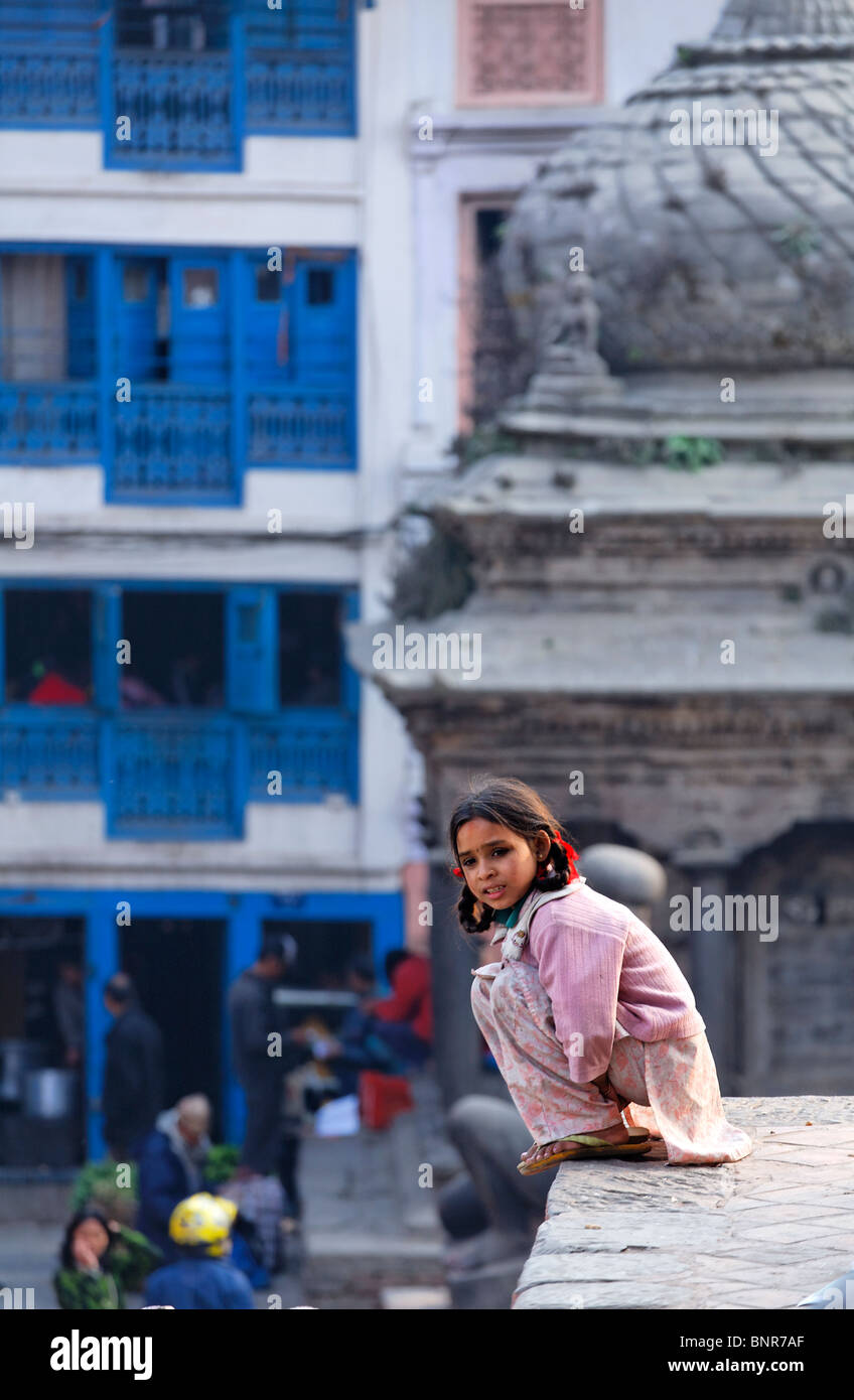 Nepal - Kathmandu - Durbar Square - girl sitting at the top of a temple Stock Photo