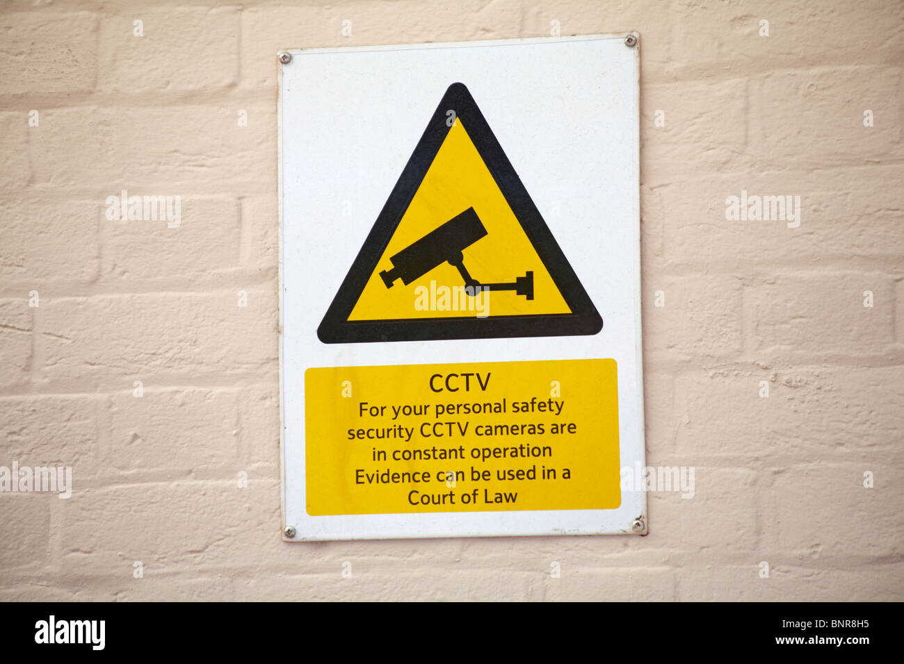 CCTV notice on buff coloured wall Stock Photo Alamy