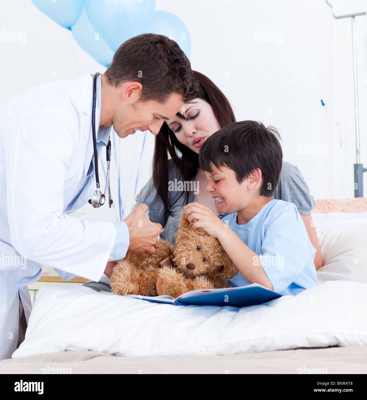 Doctor playing with a little boy and his mother Stock Photo - Alamy