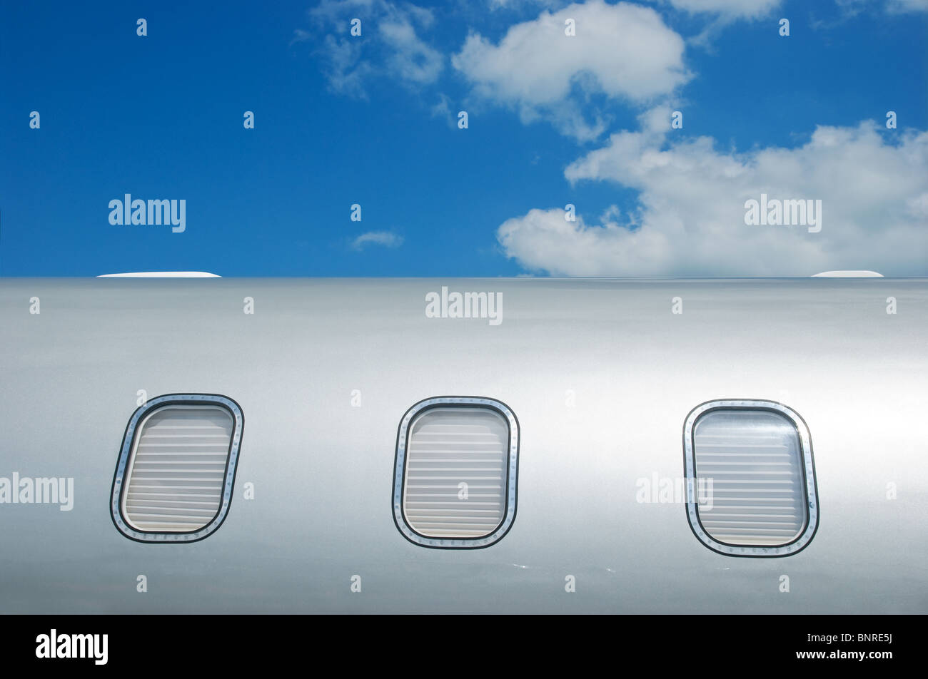 Detail of gray metallic corporate jet with windows closed by blinds. Stock Photo