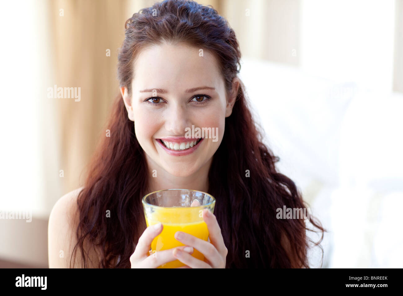 Girl Drinking Orange Juice In Bedroom Stock Photo Alamy