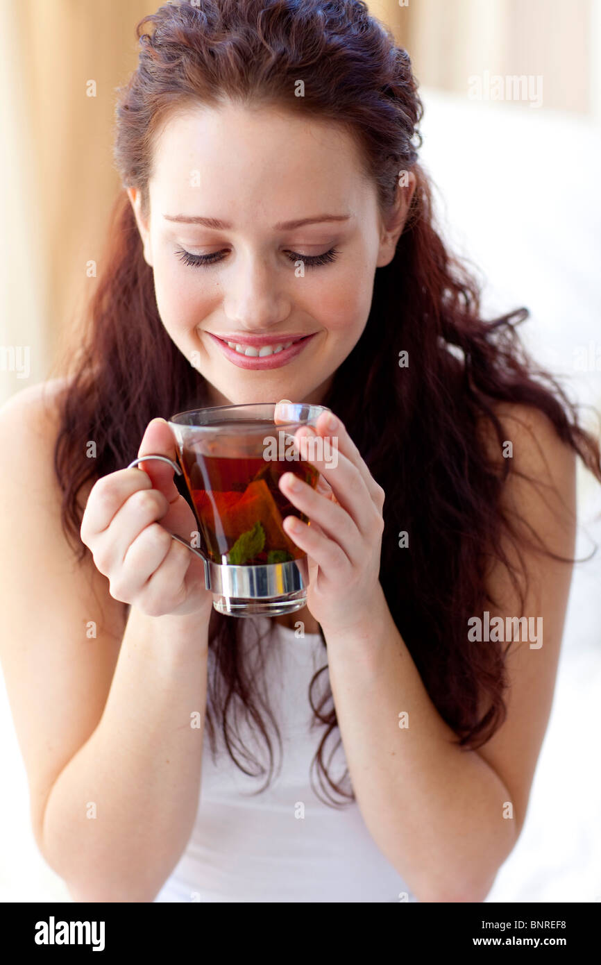Beautiful woman drinking a cup of tea in bedroom Stock Photo Alamy