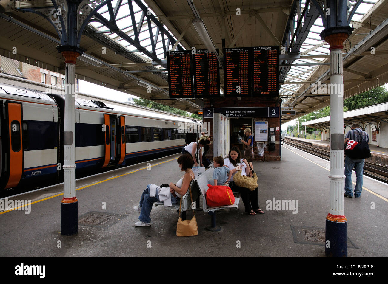 Passengers arriving and waiting for a train below the departures