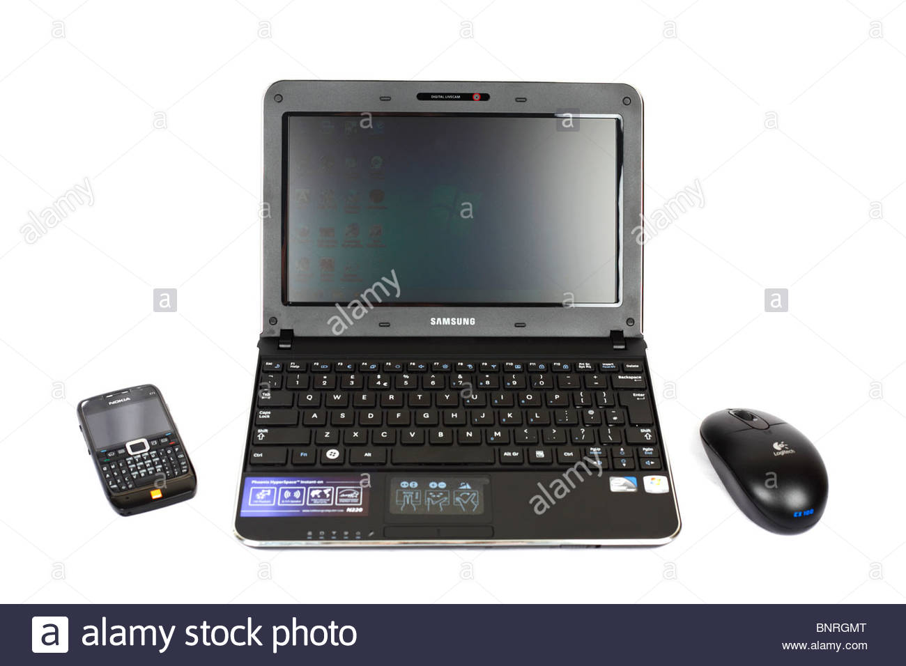 Samsung N220 Netbook, wireless optical mouse and mobile phone on white background Stock Photo