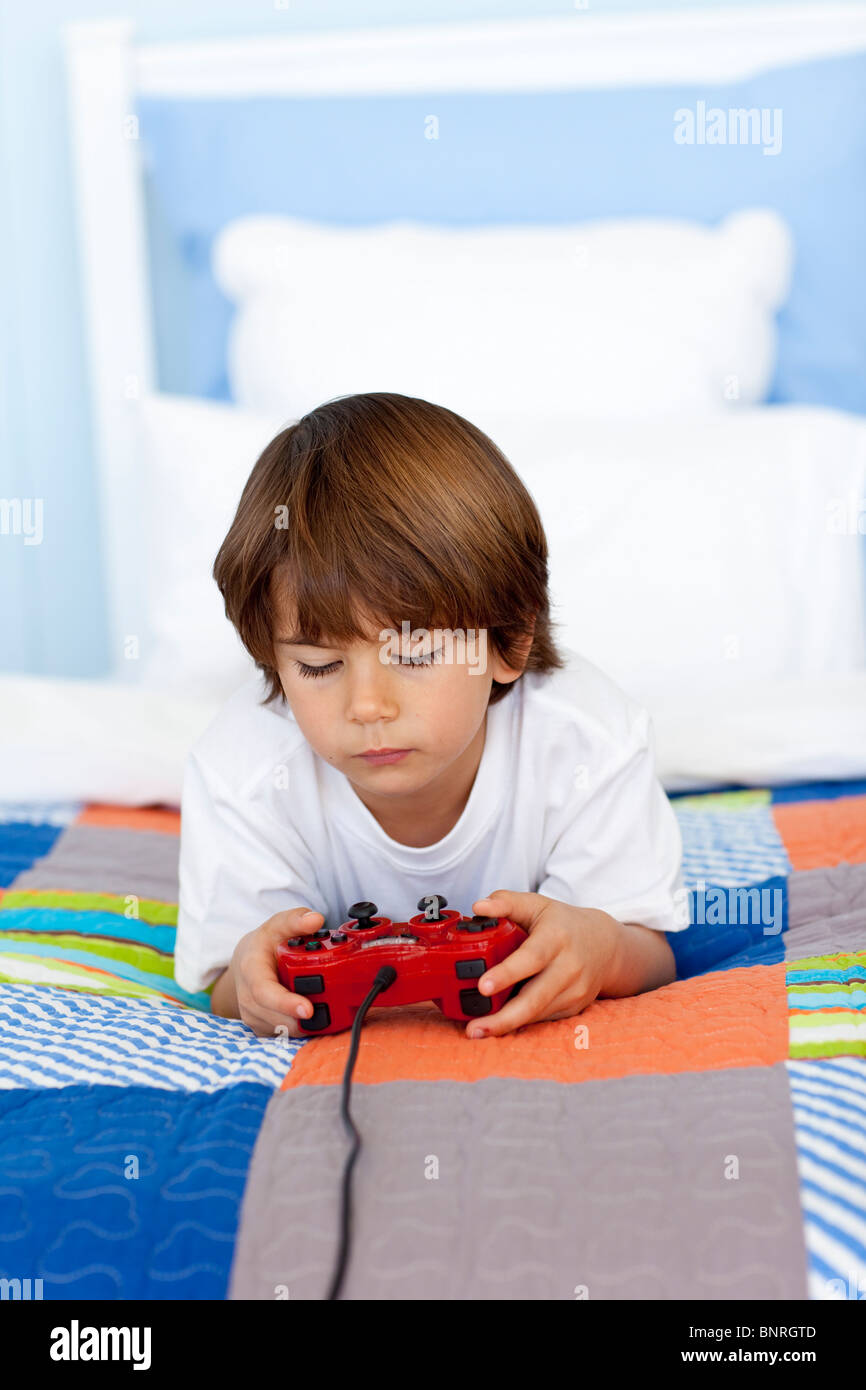 Boy playing videogames in his bedroom Stock Photo