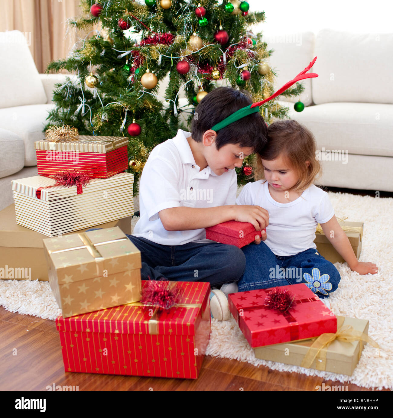 Happy brother and sister opening Christmas gifts Stock Photo - Alamy